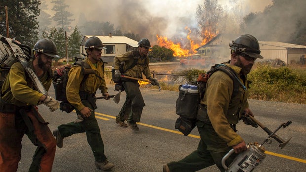 Firefighters flee as the Twisp River fire advances unexpectedly near Twisp, Washington, Aug. 20, 2015. 