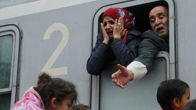 Migrants react after boarding a train at the station in Tovarnik, Croatia 