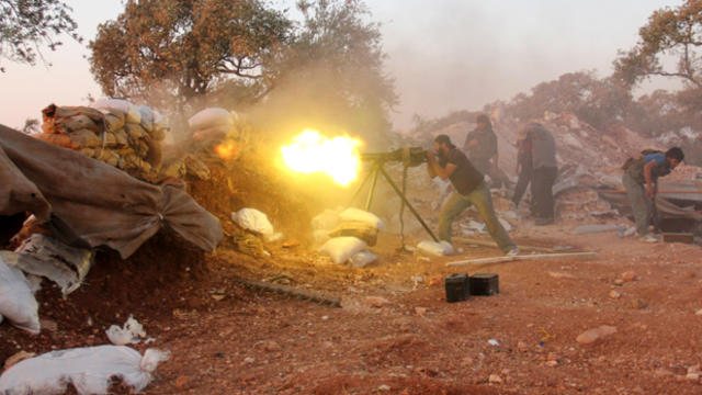 A rebel fighter fires a heavy machine gun during clashes with government forces and pro-regime shabiha militiamen in the outskirts of Syria's northwestern Idlib province Sept. 18, 2015. 