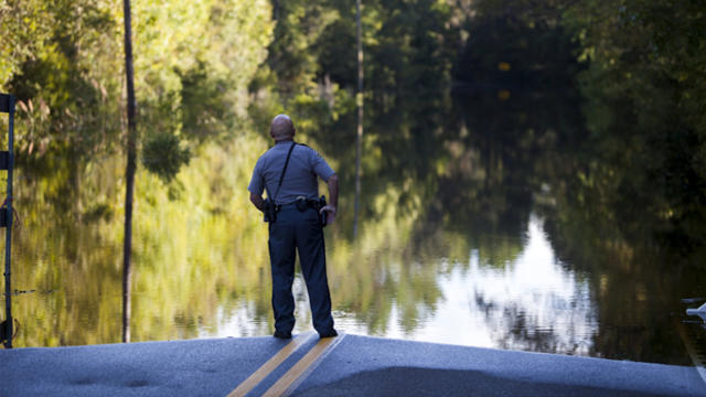 Horry County police officer Jeff Helfinstine patrols the edge of floodwaters along Lee's Landing Circle in Conway, South Carolina, Oct. 7, 2015. 