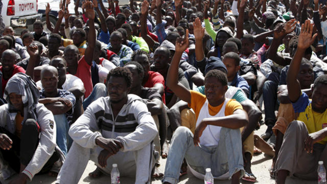 Illegal migrants sit at a temporary detention center after they were detained by Libyan authorities in Tripoli, Libya, Oct. 8, 2015. 