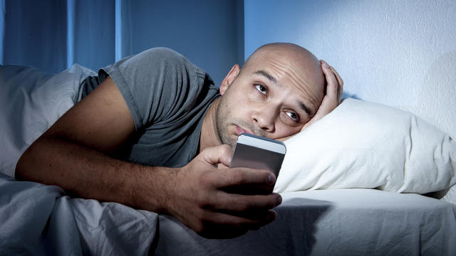 young-man-in-bed-with-cellphone-smart-phone.jpg 