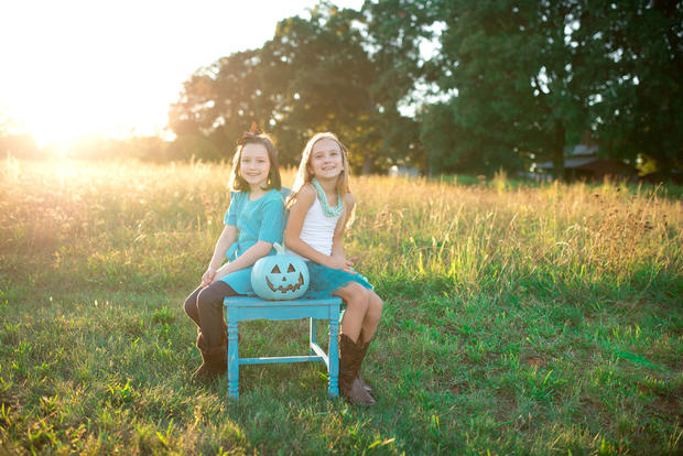 Two girls on bench with teal pumpkin 