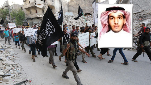 ​Members of al Qaeda's affiliate in Syria, the al-Nusra Front, march through Aleppo in a September 2014 file photo, overwhich is seen a photo of senior al Qaeda figure Sanafi al-Nasr, killed in a U.S. coalition airstrike, who was a commander f 