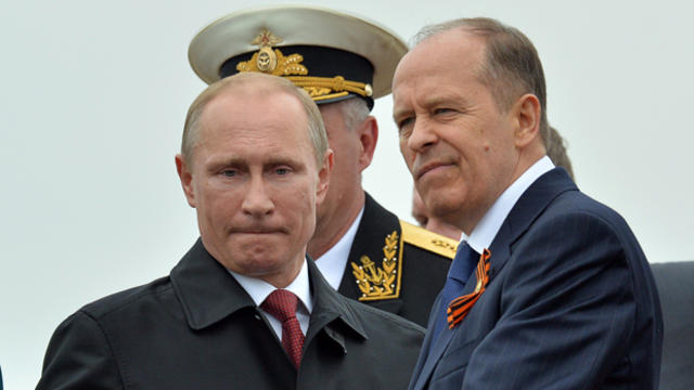 Russian President Vladimir Putin reviews Russian naval ships in the Crimean port of Sevastopol May 9, 2014, with the head of the Federal Security Service (FSB), Alexander Bortnikov, right. 