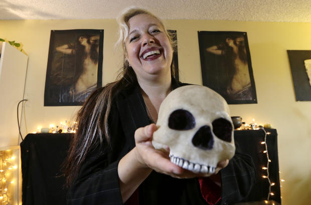 Lilith Starr, chapter head of The Satanic Temple of Seattle, holds a plastic skull while being photographed in her home Oct. 28, 2015, in Seattle. 