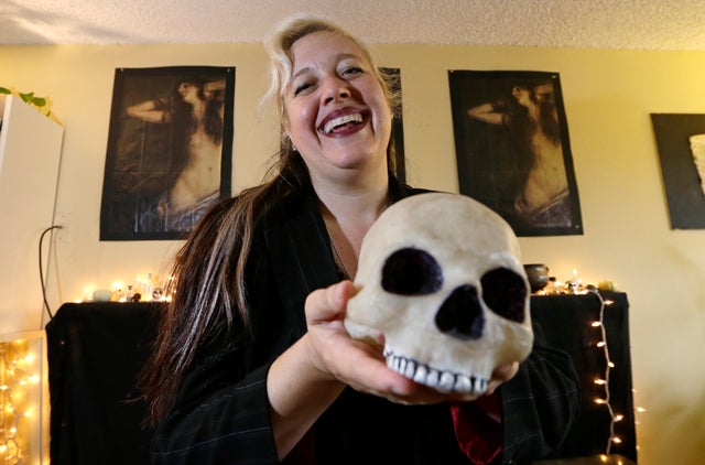 Lilith Starr, chapter head of The Satanic Temple of Seattle, holds a plastic skull while being photographed in her home Oct. 28, 2015, in Seattle.