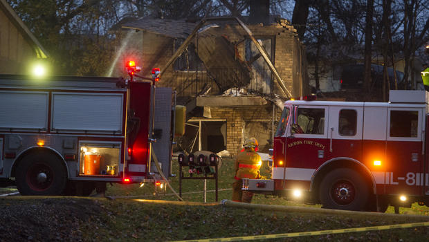 Firefighters work at the scene where authorities say a small business jet crashed into an apartment building in Akron, Ohio, Nov. 10, 2015. 