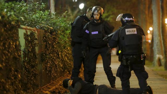 A man lies on the ground as French police check his identity near the Bataclan concert hall following fatal shootings in Paris, France, Nov. 13, 2015. 