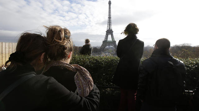 People observe a minute of silence at the Trocadero in front of the Eiffel Tower to pay tribute to the victims of the series of deadly attacks in Paris, France, Nov. 16, 2015. 