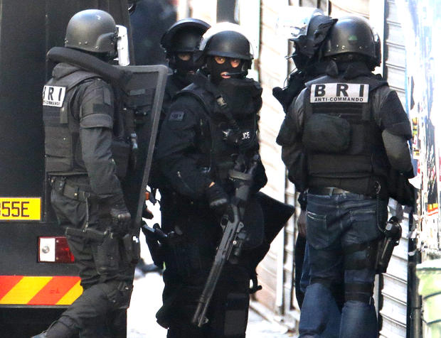 French special police forces arrive at the scene as shots are exchanged in Saint-Denis, France, near Paris, Nov. 18, 2015, during an operation to catch suspects in the deadly attacks in the French capital. 