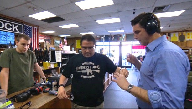 CBS News correspondent Carter Evans at Riverside Magnum Gun Range with employees Mike McGee, left, and John Galletta, right 