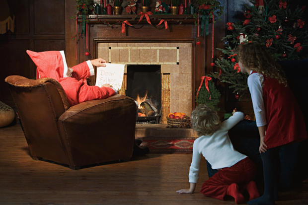 Children watching Santa Claus in living room 