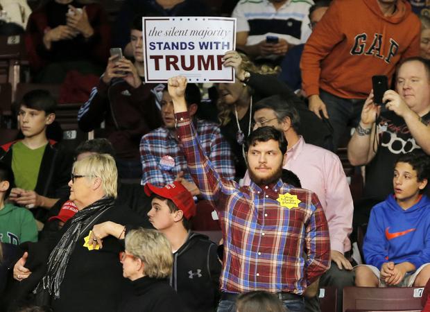A protester, center, stands as Republican presidential candidate Donald Trump speaks during a campaign event in Rock Hill, South Carolina, Jan. 8, 2016. 