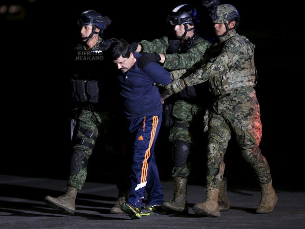 ​Recaptured drug lord Joaquin "El Chapo" Guzman is escorted by soldiers at the hangar belonging to the office of the attorney general in Mexico City Jan. 8, 2016. 