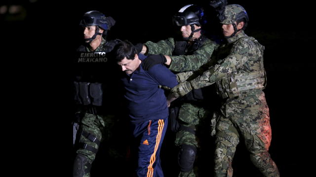 ​Recaptured drug lord Joaquin "El Chapo" Guzman is escorted by soldiers at the hangar belonging to the office of the attorney general in Mexico City Jan. 8, 2016. 