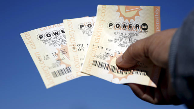 A woman holds Powerball lottery tickets outside Bluebird Liquor in Hawthorne, California, Jan. 12, 2016. 