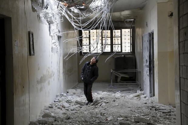 A boy inspects damage inside his school due to what activists said was an airstrike carried out by the Russian air force in Injara, Syria, Jan. 12, 2016. 