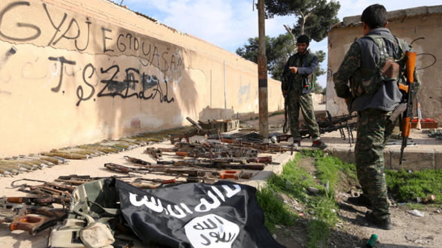 ​Fighters from the Democratic Forces of Syria inspect weapons and ammunition that, according to them, belonged to Islamic State of Iraq and Syria fighters in al-Shadadi, Syria, Feb. 26, 2016. 