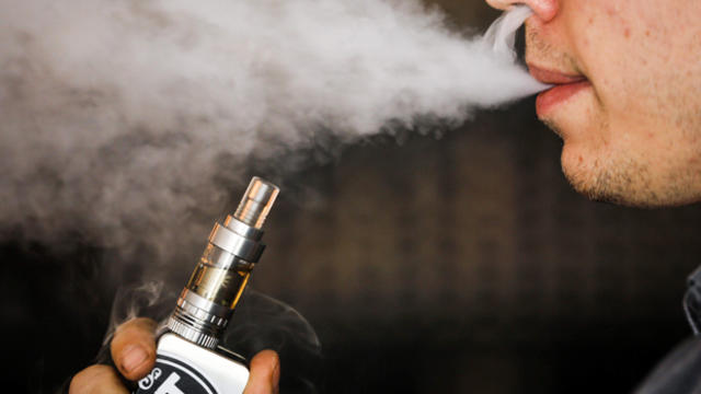 A man smokes an electronic cigarette vaporizer, also known as an e-cigarette, in Toronto Aug. 7, 2015. 