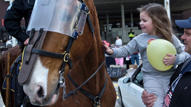 A girl pets a police horse in protective armor after a Donald Trump rally at the International Exposition Center March 12, 2016, in Cleveland, Ohio. 