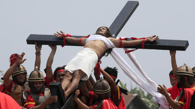 ​Ruben Enaje, who is portraying Jesus Christ for the 30th time, is lifted by residents acting as Roman soldiers during a re-enactment of the crucifixion of Jesus Christ on Good Friday in San Pedro Cutud, Philippines, March 25, 2016. 