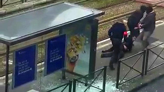 ​Belgian police drag a suspect along a tramway platform after the suspect was shot in this still image taken from amateur video in the Brussels borough of Schaerbeek March 25, 2016, three days after the bombings in Brussels, Belgium. 