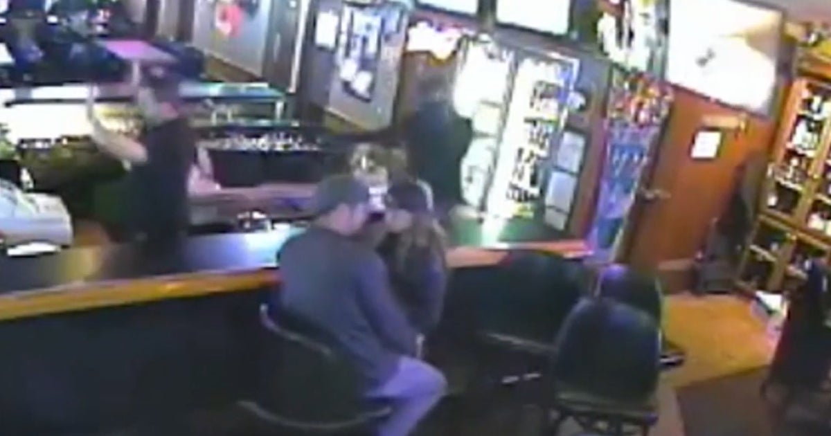 Seemingly oblivious couple kisses during bar robbery - CBS News