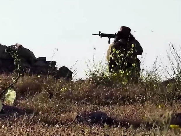 ​An image taken from video posted online by ISIS purportedly shows one of the group's militants firing on a Kurdish Peshermga position during an intense battle north of Mosul 