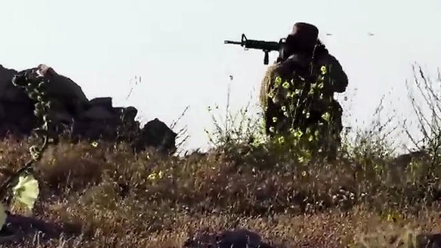 ​An image taken from video posted online by ISIS purportedly shows one of the group's militants firing on a Kurdish Peshermga position during an intense battle north of Mosul 