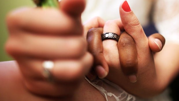 U.S. Air Force Senior Airman Shyla Smith and Courtney Burdeshaw hold hands while waiting to get married at the Manhattan Marriage Bureau the day after the U.S. Supreme Court ruling overturning the Defense of Marriage Act on June 27, 2013, in New York City 