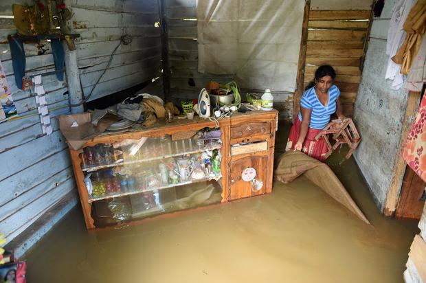 A Sri Lankan woman wades through floodwaters inside her home in Kelaniya suburb of the capital Colombo 