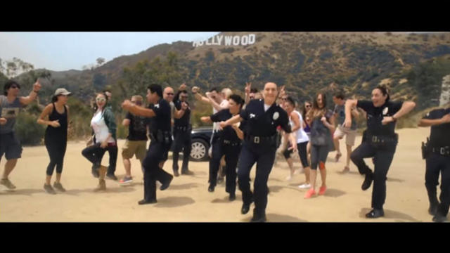 ​Los Angeles Police Department officers dance with the city's iconic Hollywood sign in the background in a video posted to the department's Facebook page. 