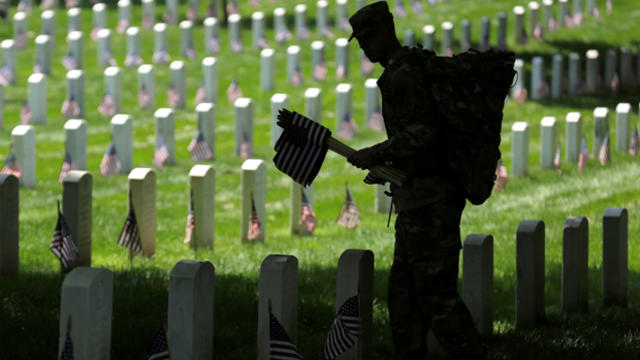 ​A soldier of the 3rd U.S. Infantry Regiment (The Old Guard) places flags in front of the graves at Arlington National Cemetery in Washington on May 26, 2016. 