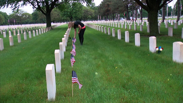 Rocky Borchardt places flags on grave sites at Ft. Snelling National Cemetery 