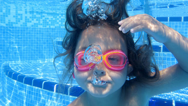 Close-up of little girl looking at camera underwater 