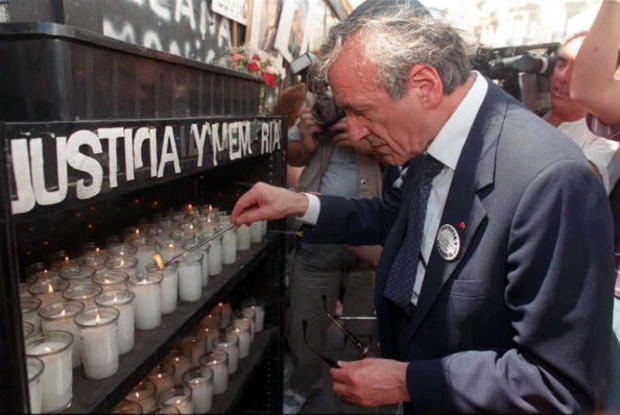 Elie Wiesel lights a candle Dec. 18, 1995, at a temporary altar set at the site of the former Argentine Jewish Mutual Association (AMIA) in Buenos Aires during a ceremony to commemorate the July 1994 bombing of the AMIA building in which 86 people died. 