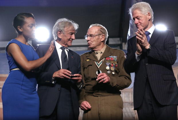 World War II veteran Scottie Ooton, third from left, who helped liberate a concentration camp, and Holocaust survivor and author Elie Wiesel, second from left, are presented with pins as presenters former President Clinton and museum staffer Rebecca Dupas 