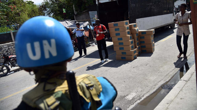 A United Nations Stabilization Mission in Haiti (MINUSTAH) soldier from Guatemala stands guard while Provisional Electoral Council members deliver electoral materials in Port-au-Prince on Oct. 24, 2015. 