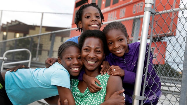 Tonia Handy, 46, is surrounded by her children, Tai Sheppard, 11, Rainn Sheppard, 10, and Brooke Sheppard, 8, left to right, after track workouts at Boys and Girls High School, in the Brooklyn borough of New York, July 11, 2016. 