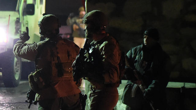 U.S. soldiers arrive at the site of a suicide car bomb attack which targeted a compound for foreign contractors near the international airport in Kabul 