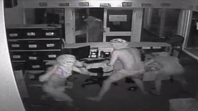 A group of men are seen inside a school where three malnourished crocodiles were found in Humpty Doo, Australia, on Aug. 21, 2016. 