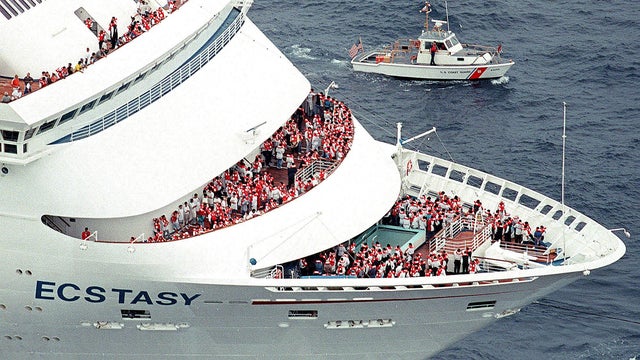 Passengers stand in their life vests on the bow of the Ecstasy, a ship owned by Carnival Cruise Lines, on July 20, 1998, on the Atlantic Ocean off Miami Beach, Florida. 