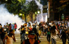 People run from flash-bang grenades in uptown Charlotte, North Carolina, during a protest of the police shooting of Keith Scott in Charlotte Sept. 21, 2016. 