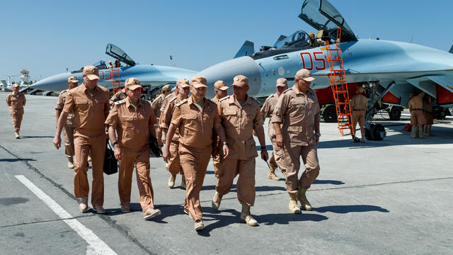 Russian Defense Minister Sergei Shoigu, center, visits the Hemeimeem air base in Syria 