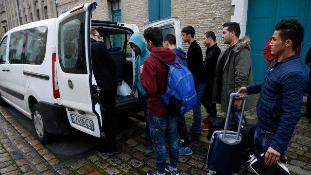 Afghani adolescent migrants place their belongins into a van as they depart the emergency shelter in Saint Omer, France, as they travel to Britain 
