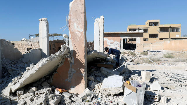 A boy inspects a damaged site after shelling in the rebel held town of Hass, Syria, Oct. 26, 2016. 