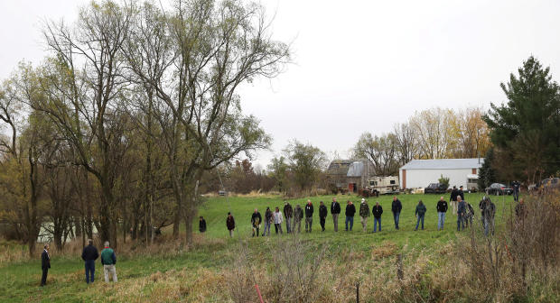 Investigators search a field near Redfield, Iowa, where the suspected gunman of two police officers who were shot and killed in separate attacks described as “ambush-style” in Urbandale and Des Moines, Iowa, turned himself in Nov. 2, 2016. 