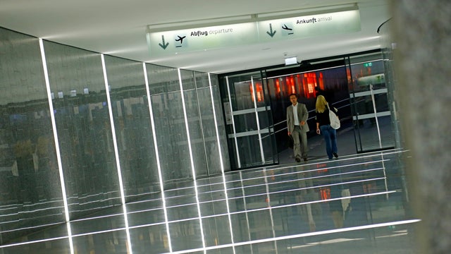 People walk at Vienna-Schwechat Airport near Vienna on July 19, 2012. 