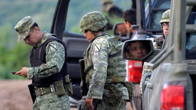 Mexican soldiers are seen on Sept. 7, 2016, in El Chauz, Mexico, near the area where a police helicopter participating in an operation to capture leaders of an unidentified criminal crashed. 